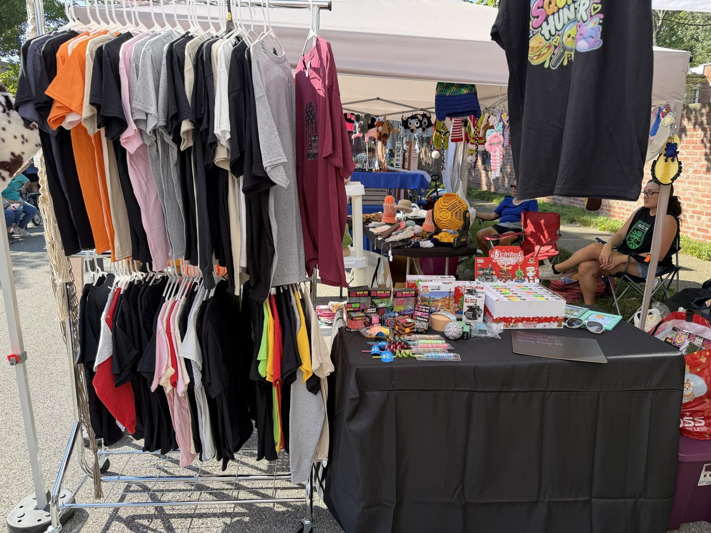 Racks full of colorful tees at an outdoor fair